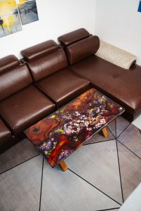 Unique magnificent sofa featuring iconic Koi, Chinese coins, cherry blossoms on mysterious dark background, red-brown Sưa wood